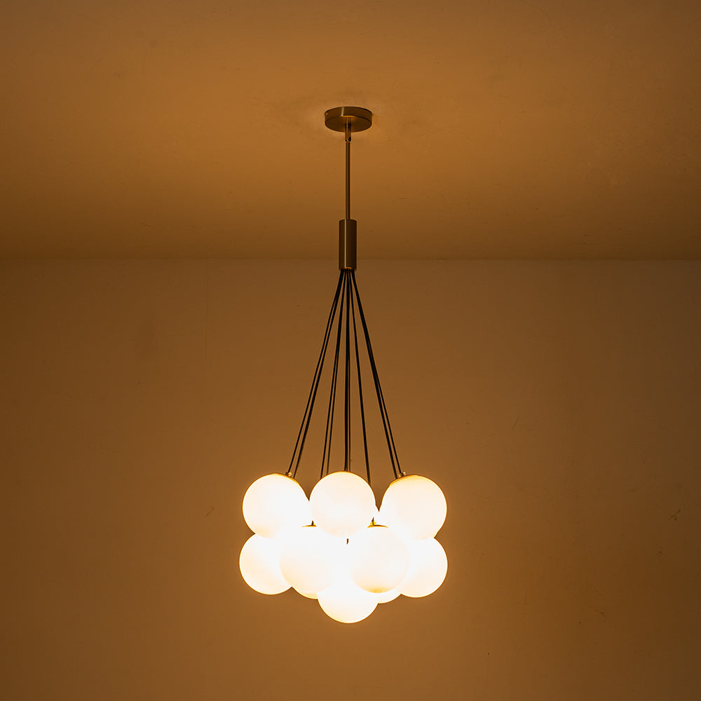 Exuding modern mid-century charm, this chic cluster chandelier effortlessly enhances any interior space with its stylish design. Crafted with a harmonious fusion of metal and opal globes, it creates a captivating visual display while illuminating the room from multiple angles. The opal glass shades, paired with 13 E26/E27 bulbs (bulbs not included), cast a warm and inviting glow throughout, perfect for creating a welcoming ambiance.